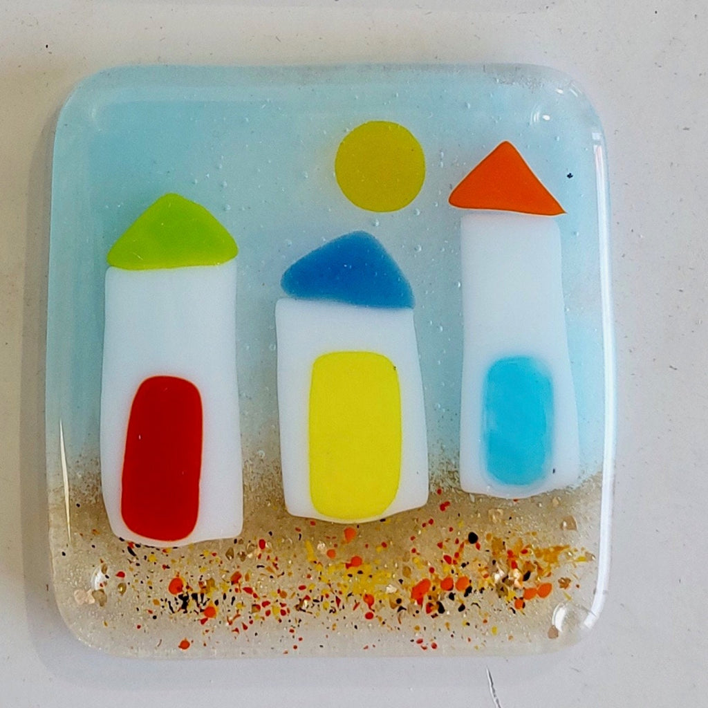 Colorful glass art piece with beach huts on the beach with sun shining
